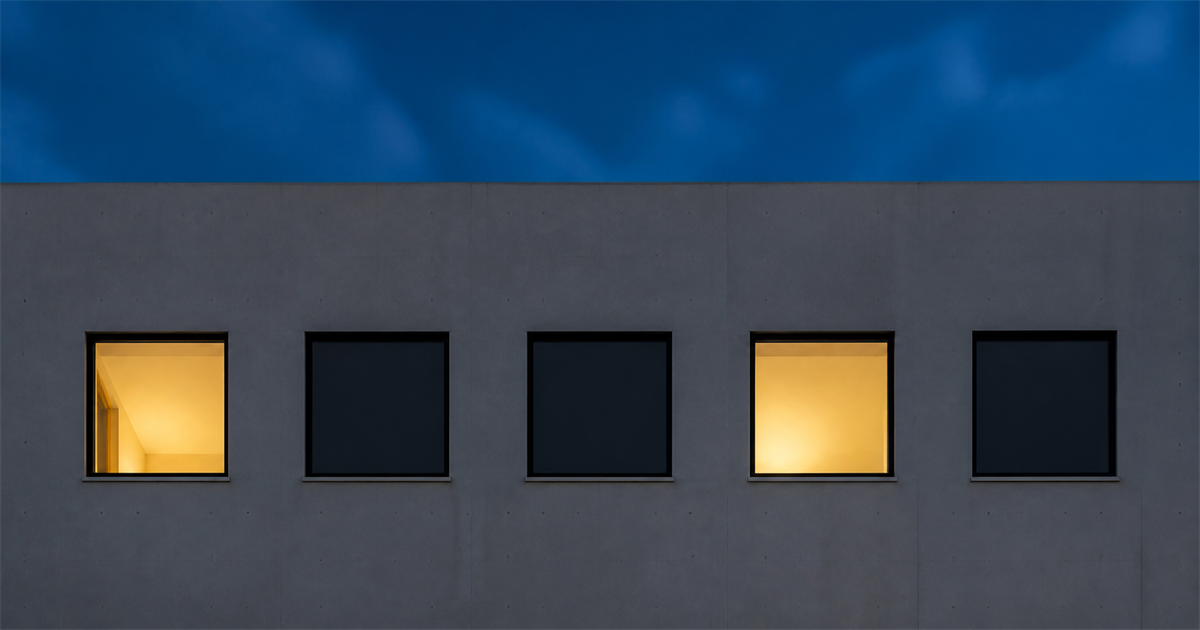 5つの窓のうち2つだけに明かりが灯る建物の外壁(承継の5要件のうち2つが人の要件であることのイメージ)