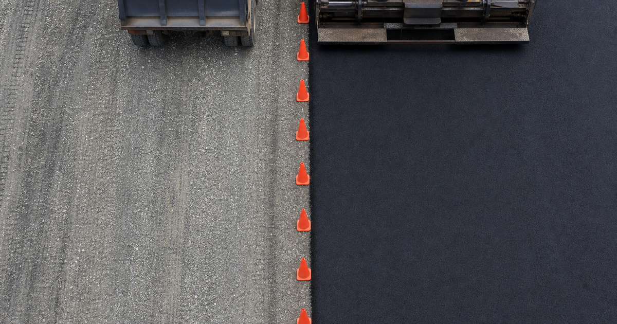 片側規制の道路を真上から見た、新しいアスファルト舗装面と切削された路盤面の対比